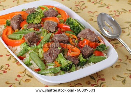 Beef stir fry with beef tips, broccoli, red peppers, and pea pods over rice