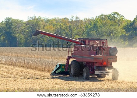 Red farm combine harvesting a soybean crop