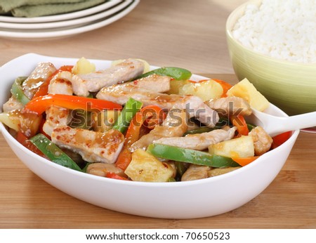 Sweet and sour pork with green and red peppers in a bowl