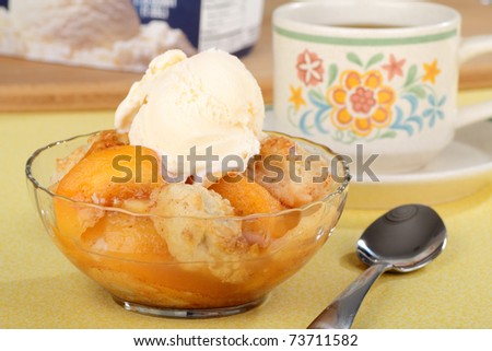 Peach cobbler with a scoop of ice cream in a bowl