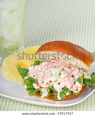 Ham salad with lettuce on a bun and pineapple slices