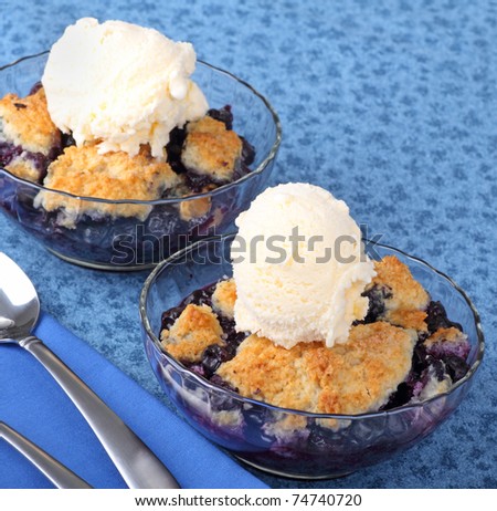 Two bowls of blueberry cobblers with a scoop of ice cream