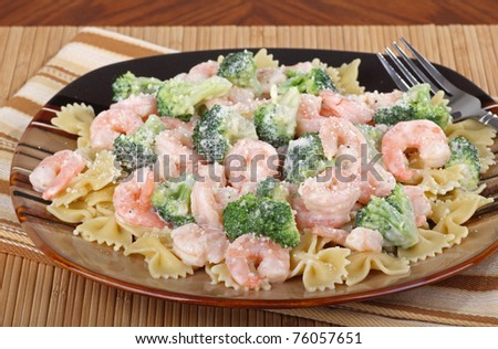 Shrimp, pasta and broccoli with a sauce on a plate
