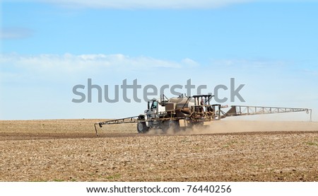 Sprayer spraying fertilizer onto a farm field