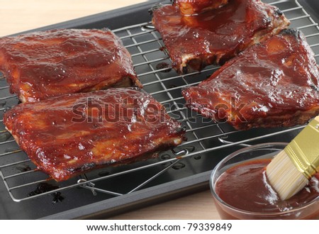 Grilled barbecue spareribs on a grill rack with barbecue sauce