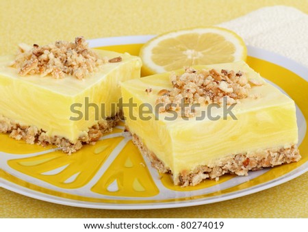 Two lemon square with a lemon slice on a plate