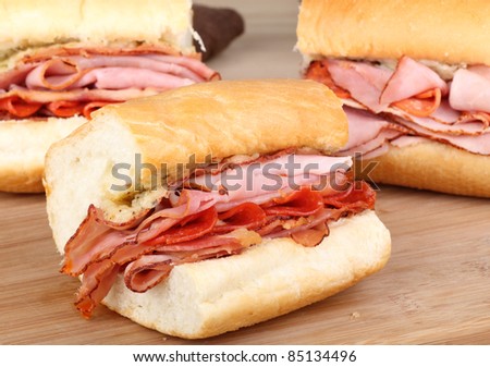 Ham, pepperoni and bacon sandwich on a cutting board