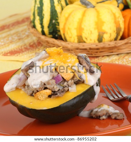 Stuffed squash on a plate with basket of squash in background