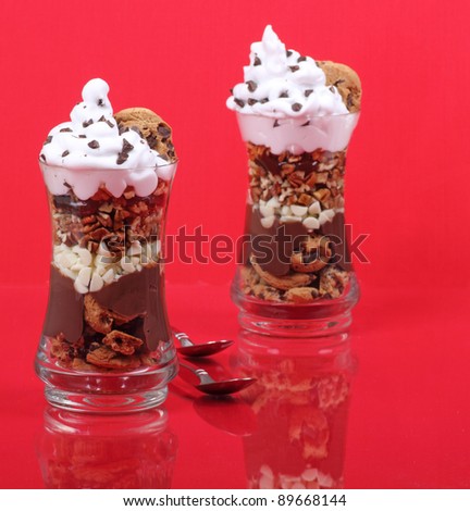 Two chocolate whipped cream desserts in a glass