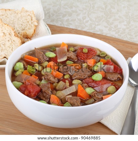 Bowl of beef and vegetable soup and bread