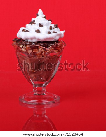 Chocolate, nut and whipped cream dessert on a red background