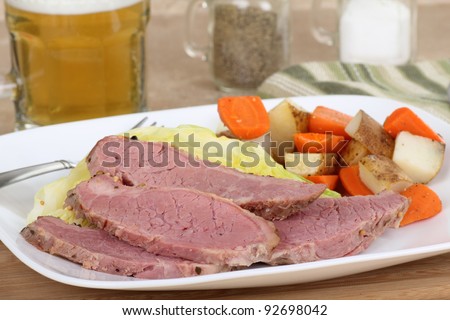Slices of corned beef with cabbage and carrots and potatoes on a dinner plate