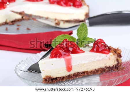Slice of cream cheese cake with cherries and a mint leaf on top