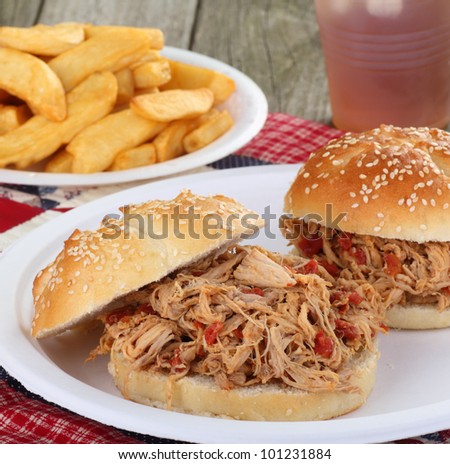 Pulled pork sandwich on a bun with french fries