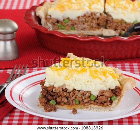 Shepherds pie slice on a plate with serving dish in background