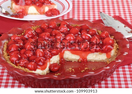 Sliced cherry cheesecake in a baking dish with piece in background