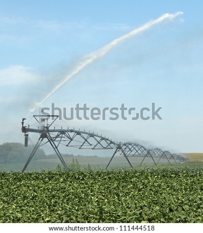 Irrigation equipment watering a green soybean crop