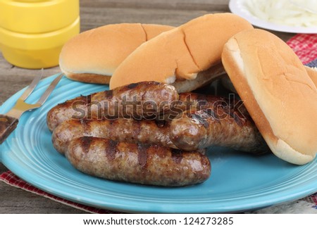 Grilled bratwursts and buns on a platter