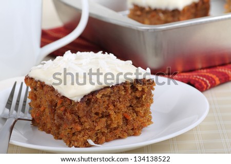 Piece of carrot cake with white icing and coconut