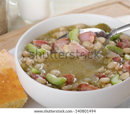 Bowl of ham and bean soup with soup on a spoon