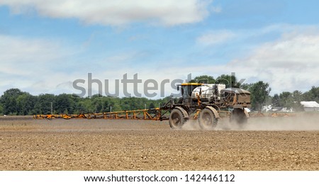 Spraying chemicals onto soil in a farm field