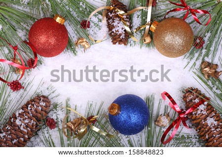 Colorful Christmas balls and pine cones and needles in the snow