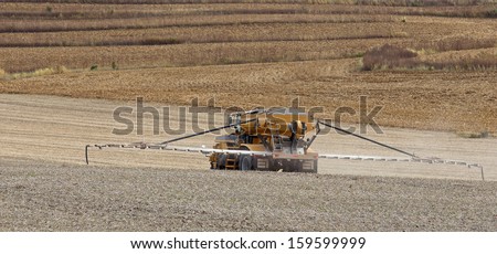 Spraying fertilizer onto a recently harvested farm field