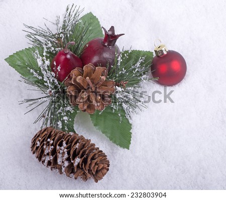 Christmas ornaments and pine cone on snow background