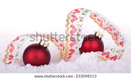 Holiday ribbon and Christmas balls in snow with white background