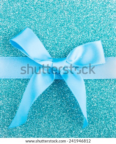 Blue holiday bow on a glittery background