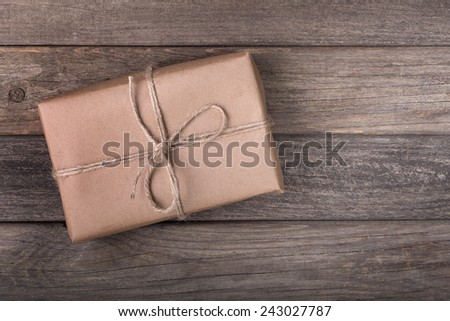 Single brown package tied with string on a wood background