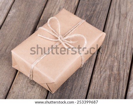 Package wrapped in brown paper and string on old wooden planks