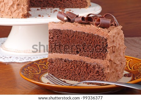 Piece of chocolate cake with chocolate curls on a plate