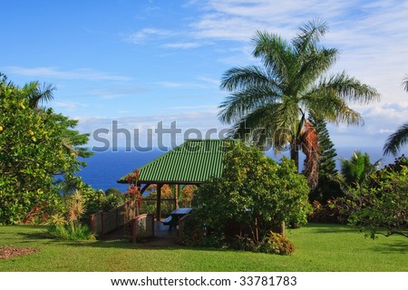 Open cabin with tropical garden and ocean on the background.