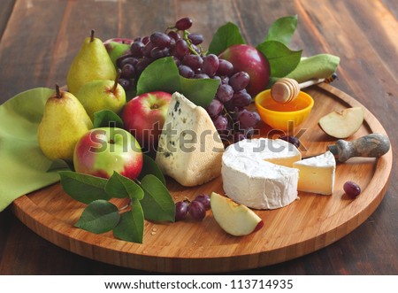 Cheese board with fruits and honey