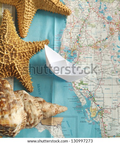 Sea trip - paper boat on sea maps background