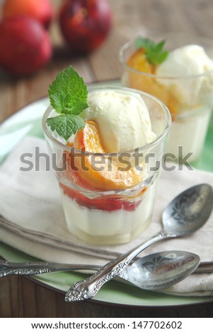 Vanilla ice cream with caramelized peaches in glass cup