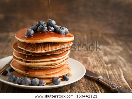Stack of pancakes with fresh blueberry and maple syrup