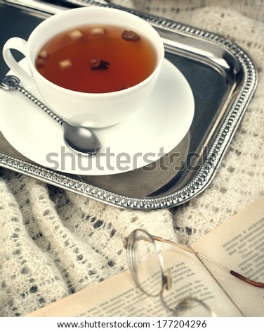 Cup of apple tea and book. Toned image