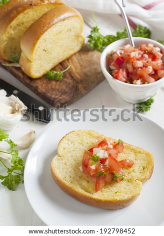 Garlic bread  topped with tomato, garlic and herbs