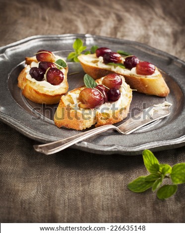 Crostini with goat cheese, grapes and rosemary