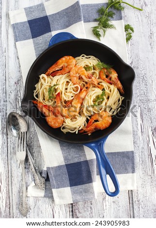 A frying pan of prawns spaghetti with creamy sauce