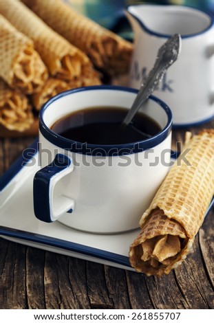 Cup of coffee and Wafer rolls filled with butter cream with condensed milk