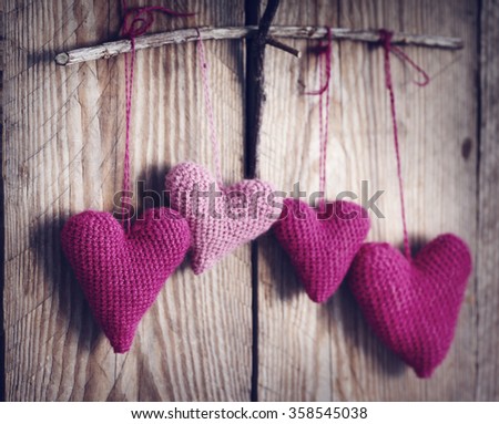 Crochet pink hearts on wooden background