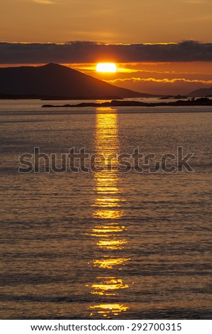Dramatic sunset over the Arctic coast of Norway with clouds and mountains