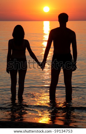 Shadow-figures of man and woman in sunset\'s beam.