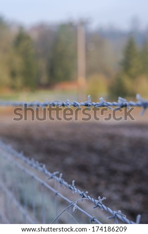 Gate with barbed wire and wooden post fences on countryside