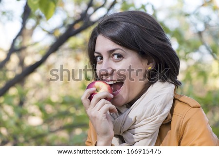 Young woman biting the red apple