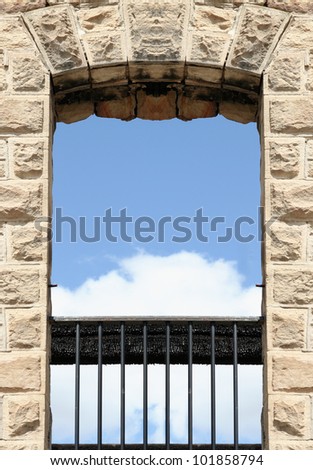 image from stone and metal texture background series (metal bars in a rock slab window with clouds and sky showing)