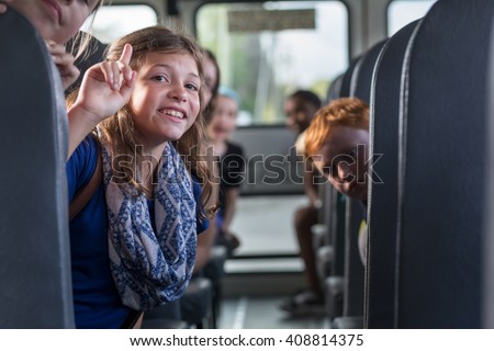 Children on the School bus - smiling girl with classmates